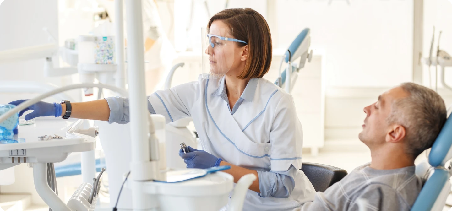 dentista atendiendo a un paciente con seguro dental Sanitas