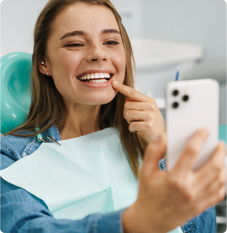 paciente de Sanitas mirando su sonrisa feliz tras su tratamiento dental