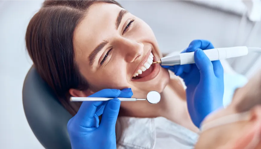 paciente sonriendo durante una limpieza dental en Sanitas