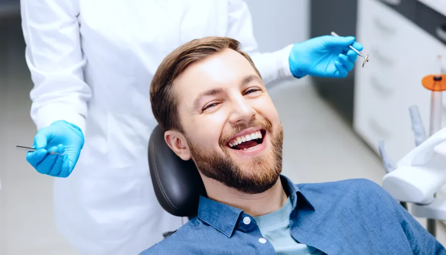 paciente sonriendo en la consulta del dentista de Sanitas